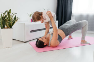 New mom bonding with her baby during her post-natal fitness routine.